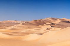 sand dunes in the desert under a blue sky