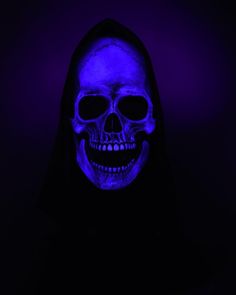 a skeleton wearing a black hood and blue light