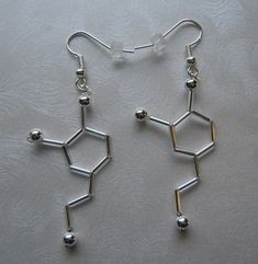 These earrings are an artistic representation of the neurotransmitter dopamine. Dopamine is the chemical in the brain responsible for love. They are made out of glass beads, silver in color. They measure 1.5 inches long. They are very lightweight and a really cute way to show off your love of science. If you would like to order multiples of this listing, message me for details. Thank you for shopping with me! Follow me on Instagram for coupon codes, new inventory, and sales! @biolojewelry I ship Science Fashion, Caffeine Molecule, Molecular Structure, Science Jewelry, Mermaid Glass, Science Biology, Pretty Box, Polish Jewelry, Biology