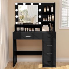 a black vanity with lighted mirror and drawers