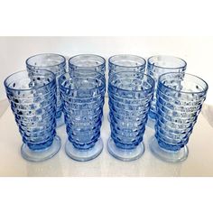 a set of six blue glass tumblers sitting on top of a table