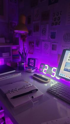 a laptop computer sitting on top of a desk next to a clock and other items