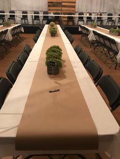 a long table is set up for an event with chairs and tables in the background