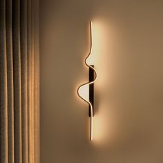 a wall light that is on the side of a wall next to a curtained window