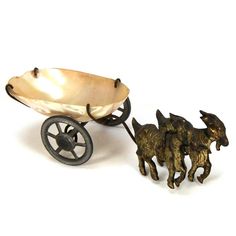 two miniature horses pulling a wagon with wheels on a white background, one being pulled by a small dog