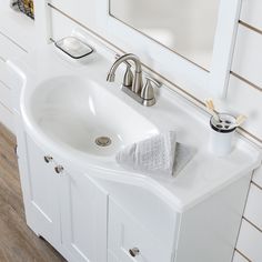 a white bathroom sink sitting under a mirror next to a wooden counter top with soap dispenser on it