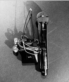 a black and white photo of an old fashioned microphone with wires attached to the mic