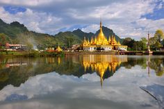 a large golden building sitting on top of a lake