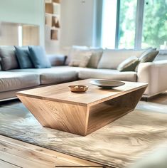 a wooden table sitting on top of a hard wood floor next to a white couch