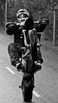 a man riding on the back of a motorcycle down a road