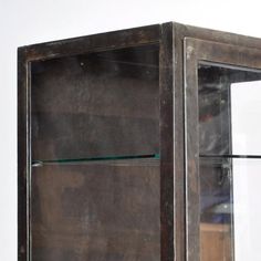 an old metal cabinet with glass shelves on top