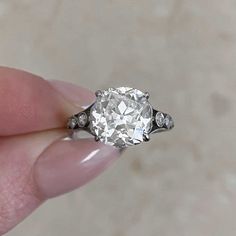 a close up of a person holding a ring with a diamond in it's center