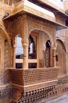 an intricately carved building on the side of a road with stone pillars and arches