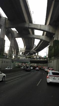 cars driving under an overpass on a highway