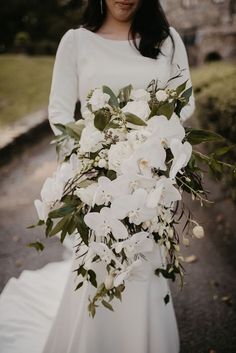 a woman in a white dress holding a bouquet of flowers