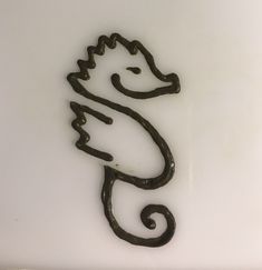 a metal sea horse on a white surface