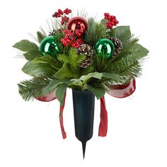 a vase filled with christmas decorations and greenery