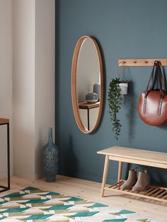 a living room with blue walls and wooden furniture, including a round mirror on the wall