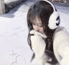 a girl wearing headphones in the snow with her hand on her face and writing i love you