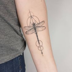 a woman's arm with a dragonfly tattoo on the left side of her arm