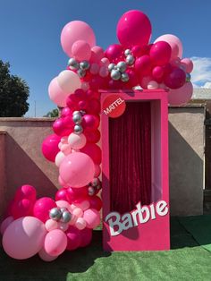 a pink and silver balloon arch with the name barbie on it