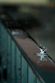 a broken glass on top of a metal rail