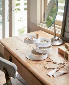 a wooden table topped with plates and bowls next to a mirror on top of it