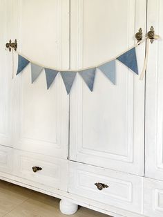 a blue and white bunting banner hanging from the side of a cabinet in a room