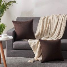 a living room with a gray couch and two brown pillows on the back of it