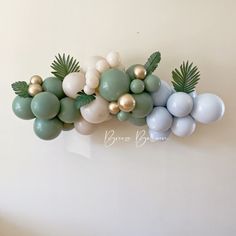 balloons and greenery are arranged on the wall