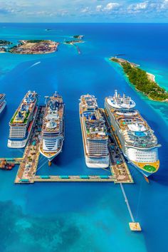 several cruise ships are docked in the water next to an island with two smaller ones