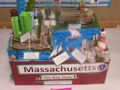 a model of massachusetts is displayed on a table in front of a sign that says the bay state