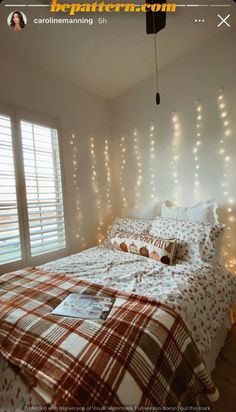 a bed sitting in a bedroom under a window covered in white lights and string lights