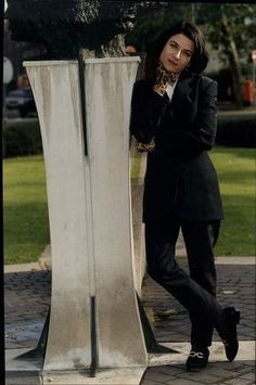 a woman standing next to a tall metal object