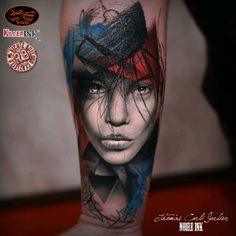 a woman's face with red, blue and black ink on the leg tattoo