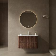 a bathroom with a round mirror above the sink and wooden cabinet below it on the wall