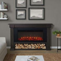 a living room with a fire place and pictures on the wall above it, along with a coffee table