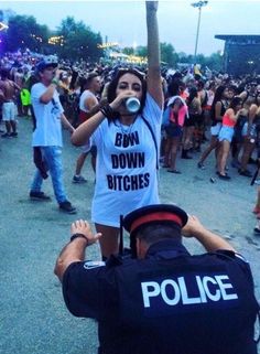 a police officer standing next to a woman in front of a crowd at a concert