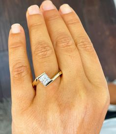 a woman's hand with a ring on it and a diamond in the middle