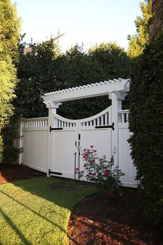 a white garden gate in the middle of a yard