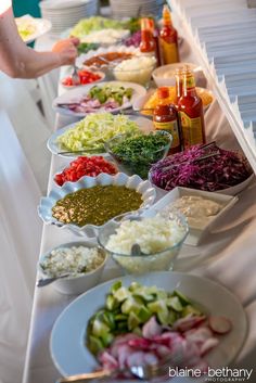 a long table filled with lots of different types of salads and condiments