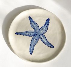 a blue and white plate with a starfish design on it