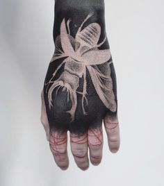 a person's hand with black and white tattoos on it