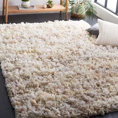 a large white rug on top of a hard wood floor