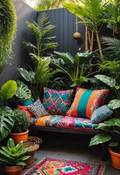 an outdoor seating area with plants and rugs