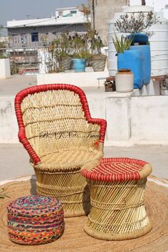 two wicker chairs sitting on top of a rug next to a foot stool and ottoman