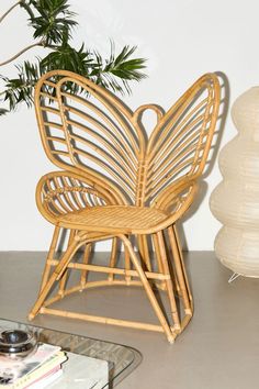 a wicker butterfly chair next to a plant