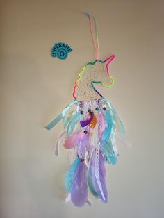 a colorful dream catcher hanging on the wall next to a blue bird ornament