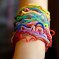 a child's arm with colorful bracelets on it