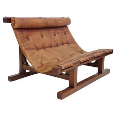 a brown leather chaise lounge chair sitting on top of a wooden frame